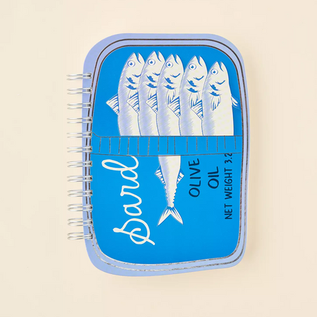 Blue oil container with fish design journal on a beige background