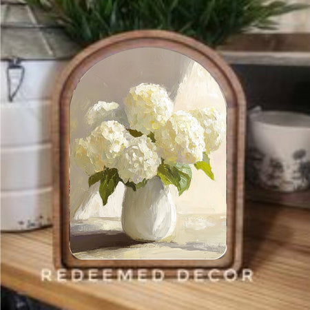 Decorative mirror with a floral design on a wooden surface, featuring the brand 'Redeemed Decor'.