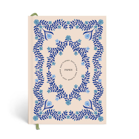 Notebook with blue floral design on a beige background