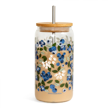 Glass tumbler with floral design, wooden lid, and metal straw on a white background