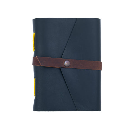 Dark blue notebook with a brown leather strap on a white background