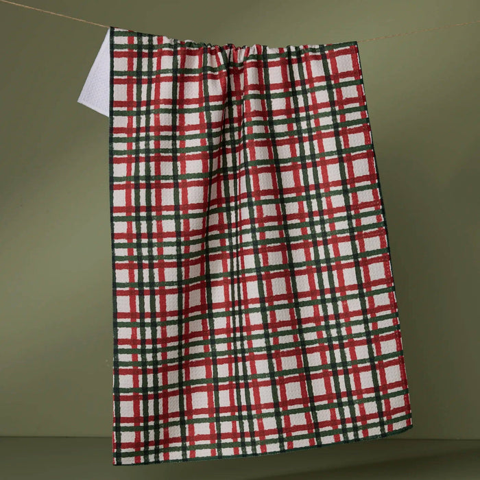 Plaid towel hanging on a line against a green background