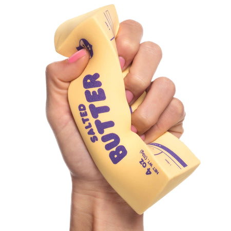 Hand holding a novelty salted butter container with purple text on a white background