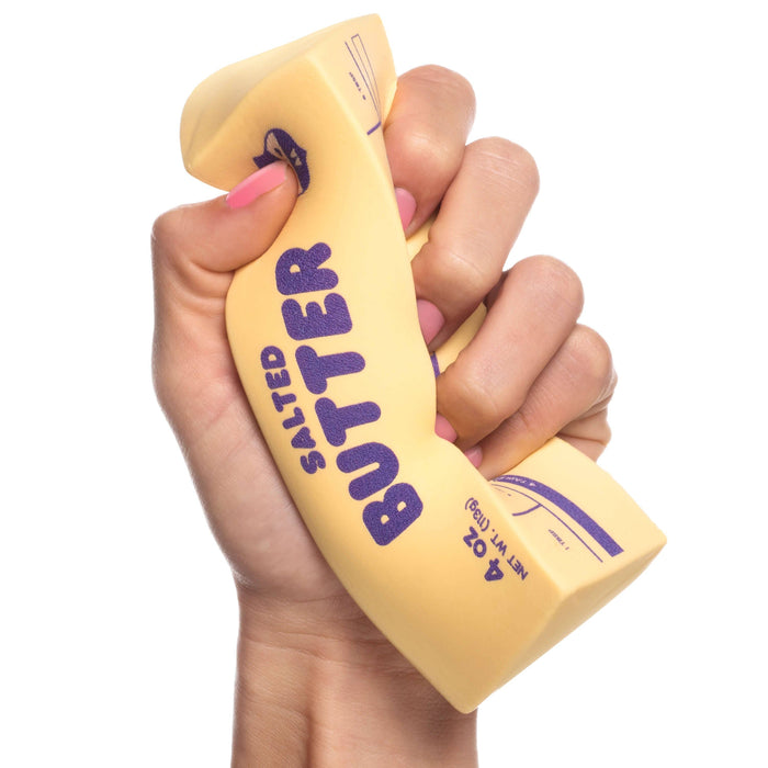 Hand holding a novelty salted butter container with purple text on a white background