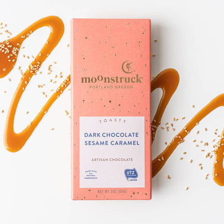 Moonstruck dark chocolate sesame caramel bar packaging with caramel drizzle on a white background