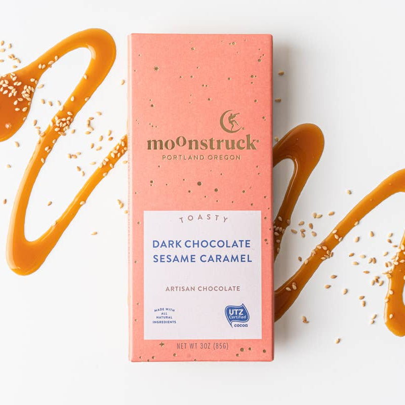 Moonstruck dark chocolate sesame caramel bar packaging with caramel drizzle on a white background
