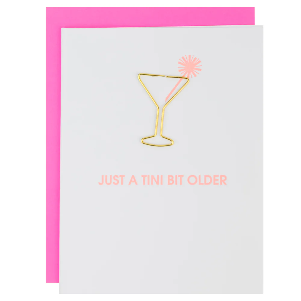 white birthday card featuring a gold martini glass shaped paper clip and reads "just a tini bit older"