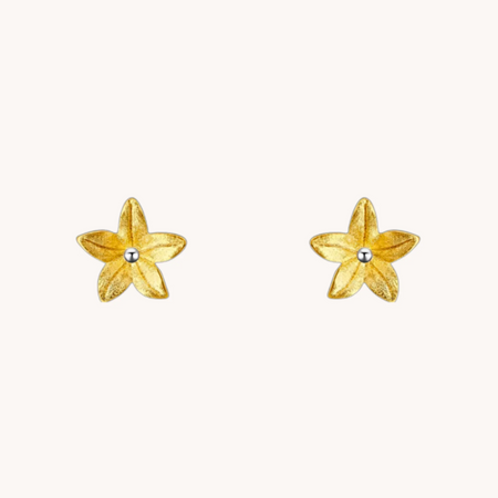 Summer Lily Gold Studs shown on an ear, with sculptural gold flower petals and a small silver center.