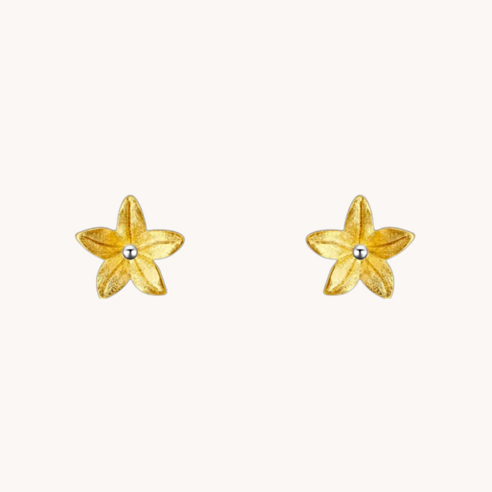 Summer Lily Gold Studs shown on an ear, with sculptural gold flower petals and a small silver center.