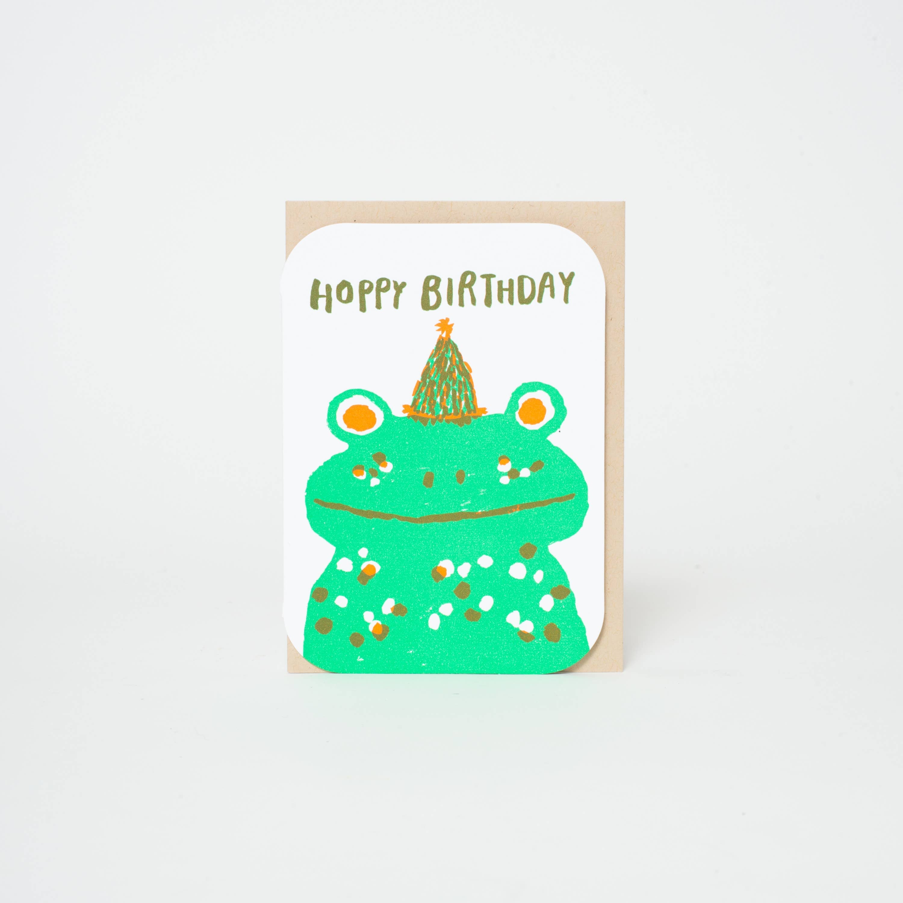 Birthday card with a green frog illustration and 'Happy Birthday' text on a white background