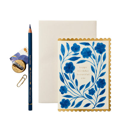 A greeting card that reads happy birthday beautiful one with a blue floral print on the front, accompanied by a beige envelope.