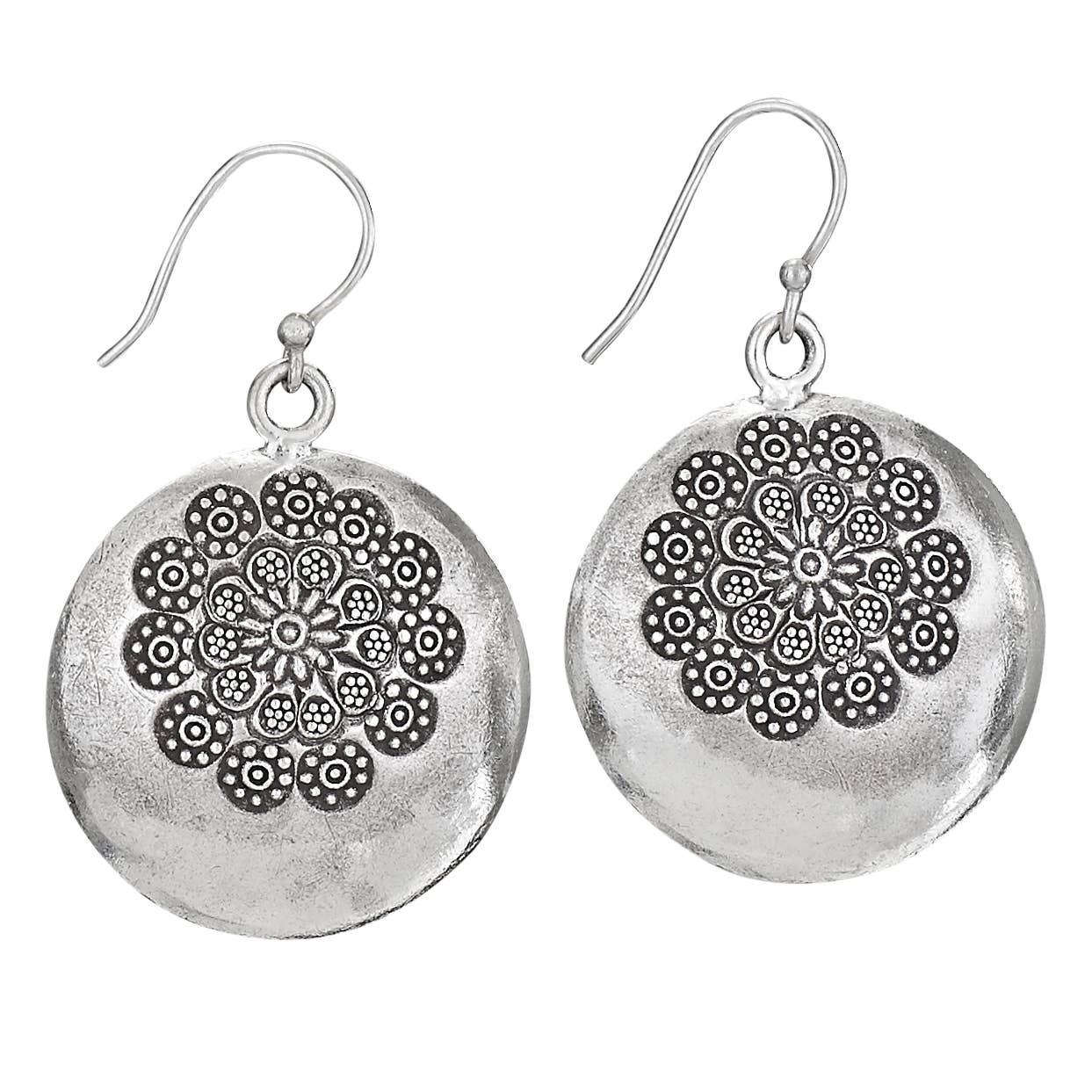 A pair of silver-toned round drop earrings with a textured finish and an intricate floral mandala pattern on the front, hanging from fishhook wires against a plain white background.