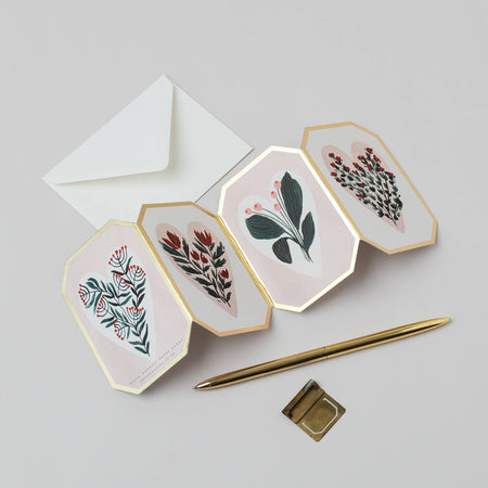 Four hexagonal cards with floral designs, a white envelope, and a gold pen on a light gray background.