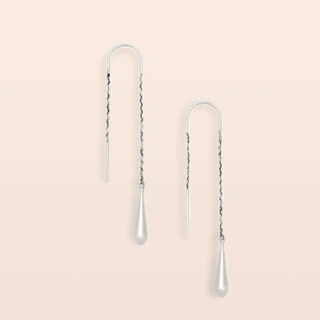 Pair of silver chain earrings on a light pink background