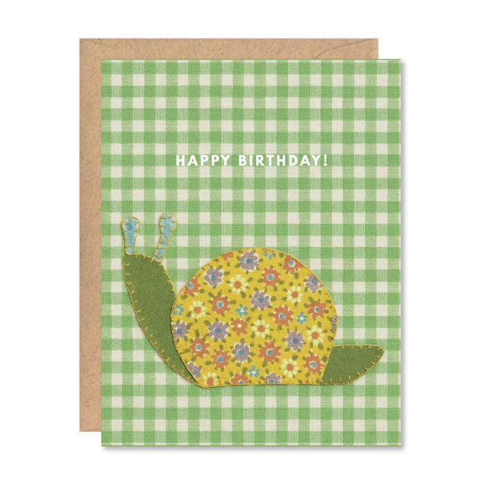 Birthday card with a floral snail design on a green checkered background
