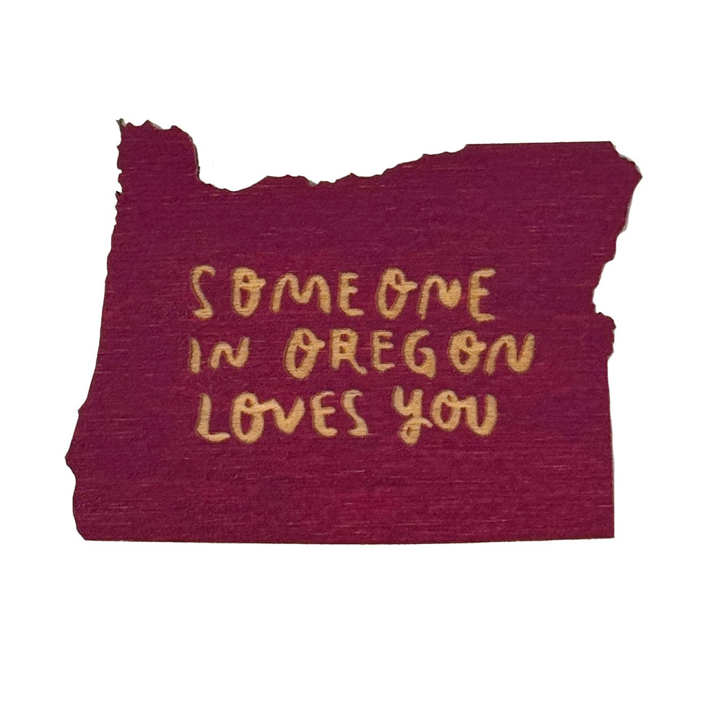 A die-cut magnet shaped like the state of Oregon, featuring a textured deep burgundy background with the phrase 'SOMEONE IN OREGON LOVES YOU' written in a gold handwritten font, shown on a plain white background.