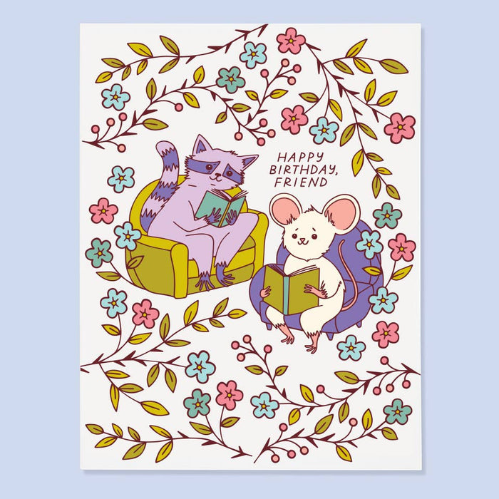 Illustration of a cat and mouse reading books with floral decorations on a birthday card.