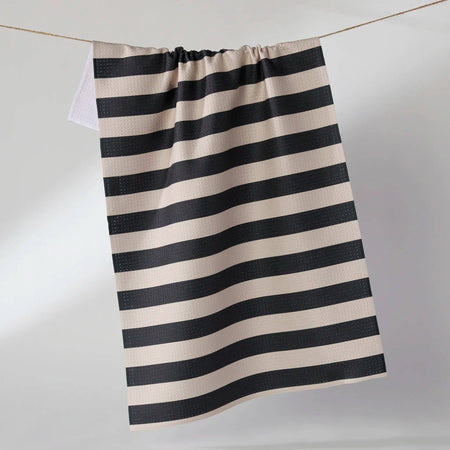 Black and white striped towel hanging on a line against a plain background