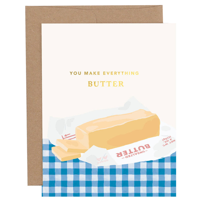 Greeting card with a stick of butter illustration and text 'You Make Everything Butter' on a blue checkered background.