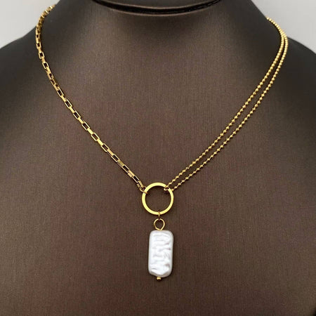 Gold necklace with a white imitation pearl on a mannequin