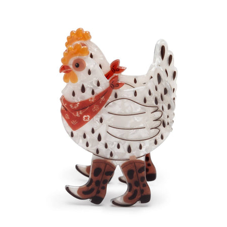 A fun hair clip of a speckled white hen wearing a red bandana and brown cowboy boots, set against a plain white background.