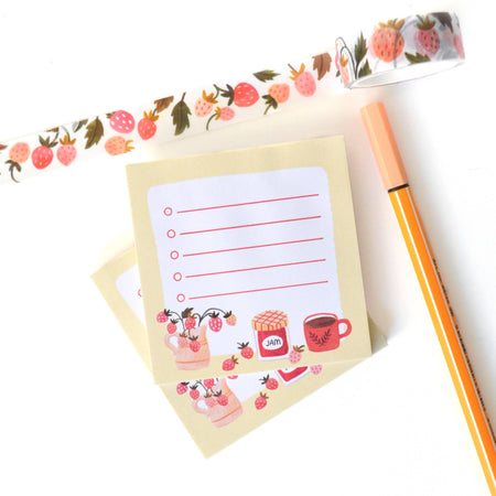 Notebook with floral border, pen, and decorative tape on a white background