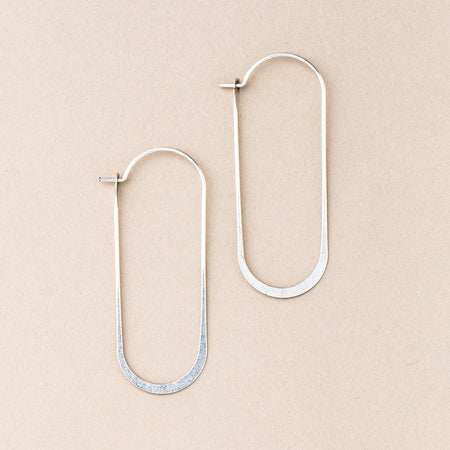 Pair of silver hoop earrings on a beige background