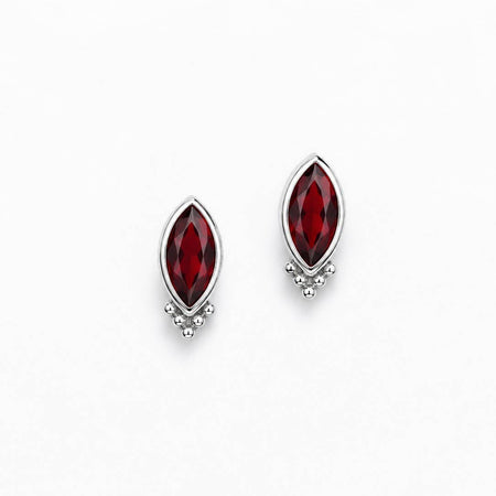 A pair of silver stud earrings featuring marquise-cut deep red gemstones with a small cluster of clear stones at the bottom, set against a plain white background.