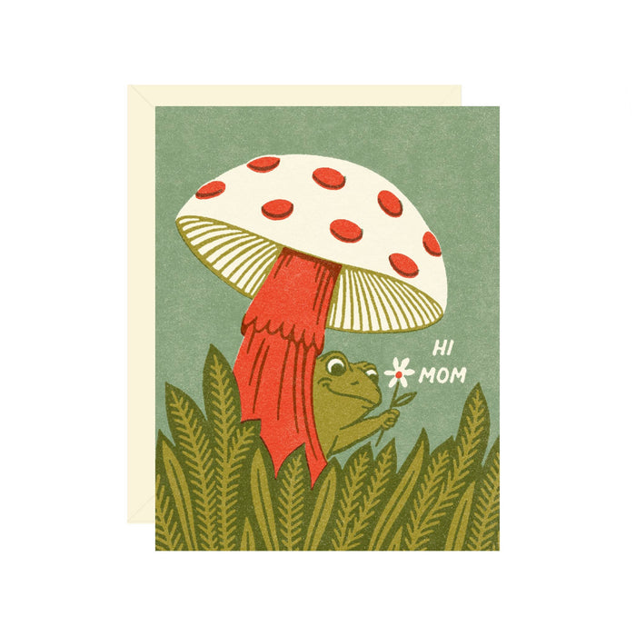Greeting card with a frog and mushroom illustration and 'Hi Mom' text on a green background.