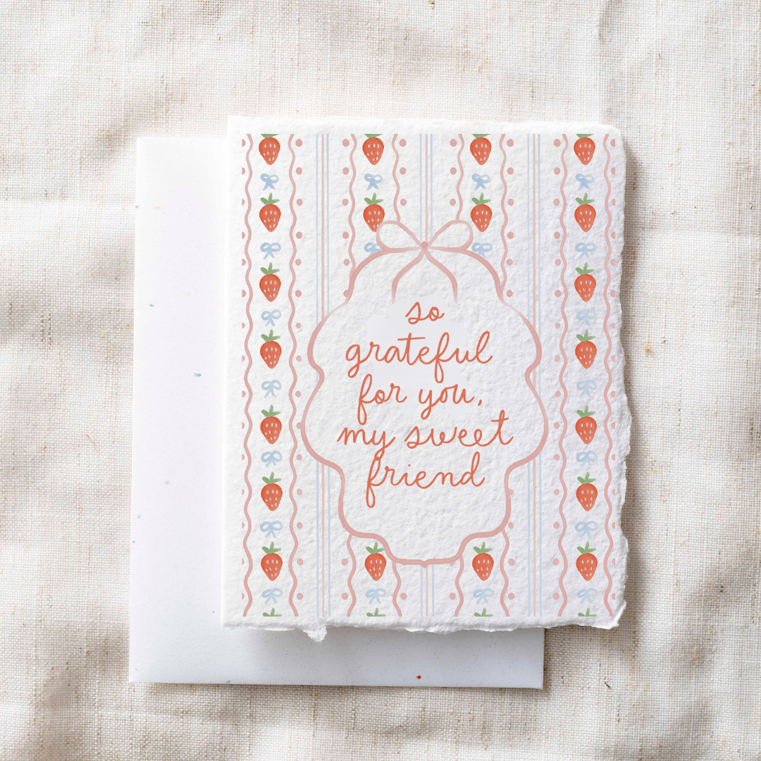 Greeting card with strawberry pattern and text on a textured surface