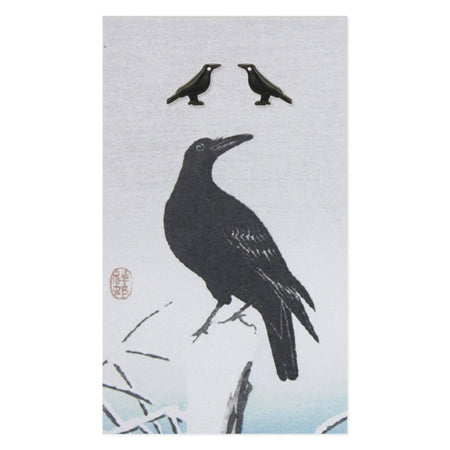 Silhouette of a crow on a branch with two smaller crows above on a light gray background