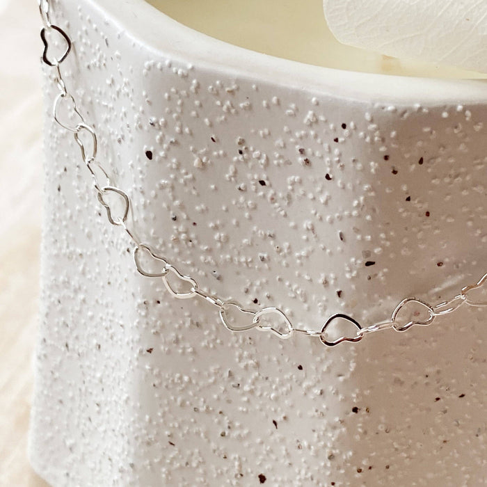 Silver chain necklace on a textured white surface