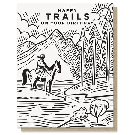 Birthday card with a black and white illustration of a person on horseback in a mountainous landscape, with 'Happy Trails on Your Birthday' text.