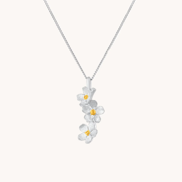 Silver necklace with cherry blossom drop with gold centers on a white background
