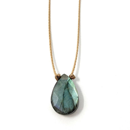 A teardrop-shaped labradorite pendant necklace on a light tan cord, shown against a plain white background.