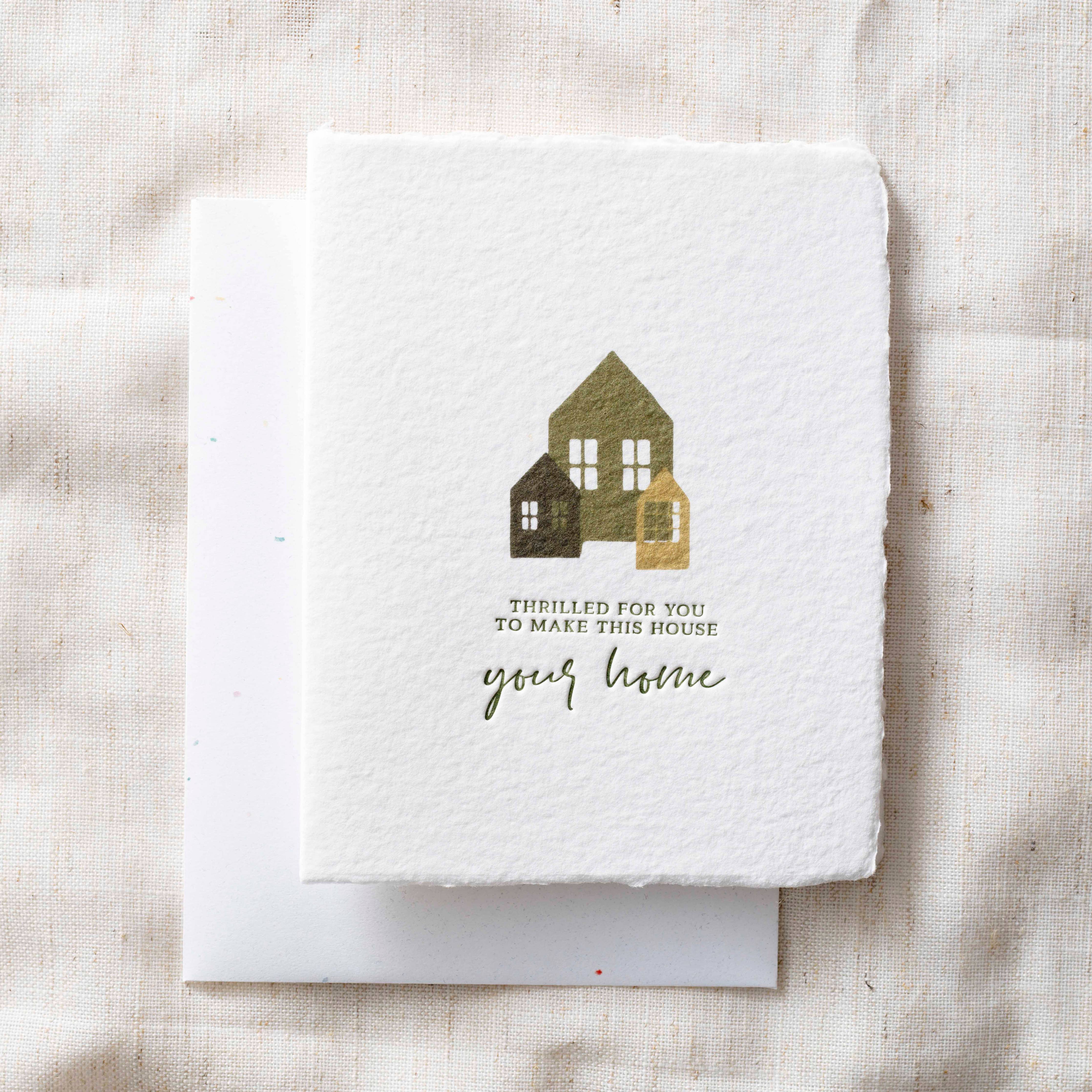 Greeting card with house illustration and text on a textured fabric background
