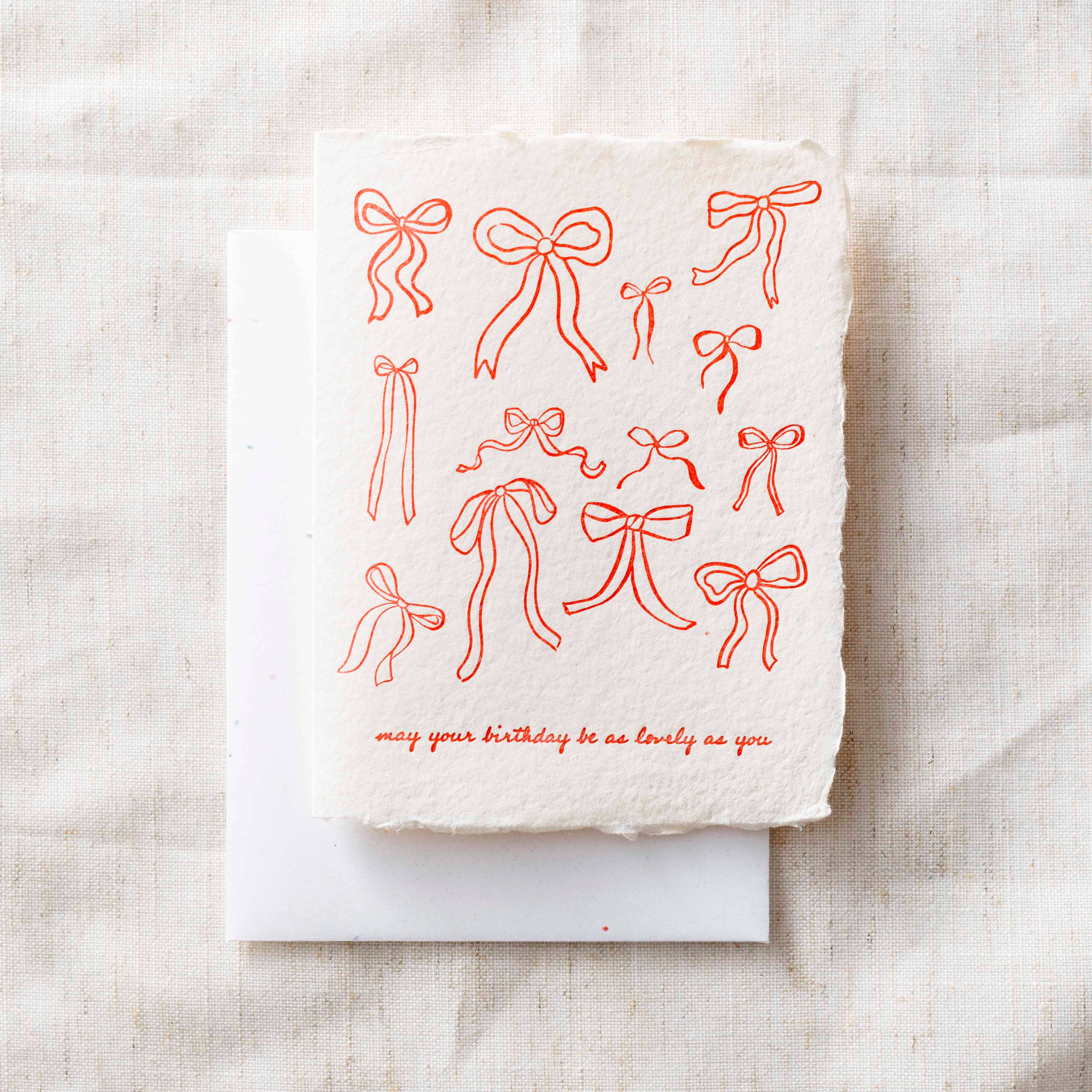 Card with red bows and text on a textured beige background