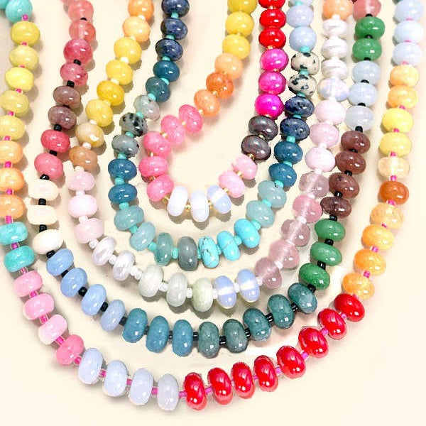 Colorful beaded necklaces arranged on a light background