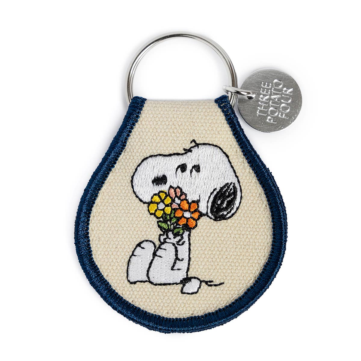 Keychain with embroidered design of Snoopy holding flowers, on a white background.