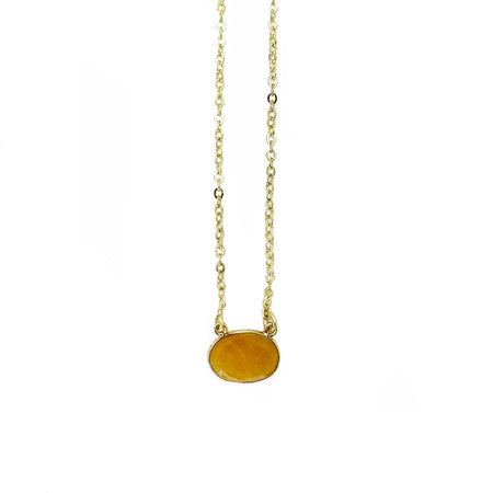 A delicate gold chain necklace featuring a small, oval-shaped amber-yellow stone pendant, shown against a plain white background.