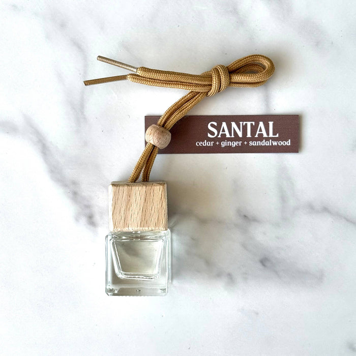 Santal-scented car air freshener with wooden cap on marble surface