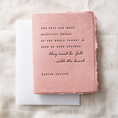 Pink textured book with Helen Keller quote on a light fabric background