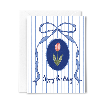 A2 size birthday card with a blue and white striped background, a central tulip flower with a bow and 'Happy Birthday' text, and a white envelope.