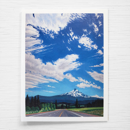 Card of a mountain landscape with a road and blue sky.