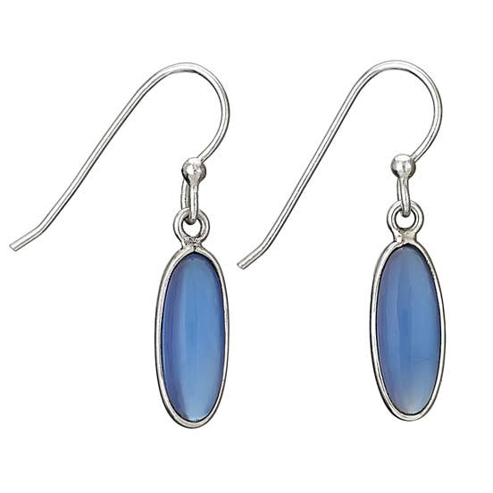 A pair of silver drop earrings featuring oval blue cabochon gemstones in silver bezel settings, suspended from silver fishhook wires on a plain white background.
