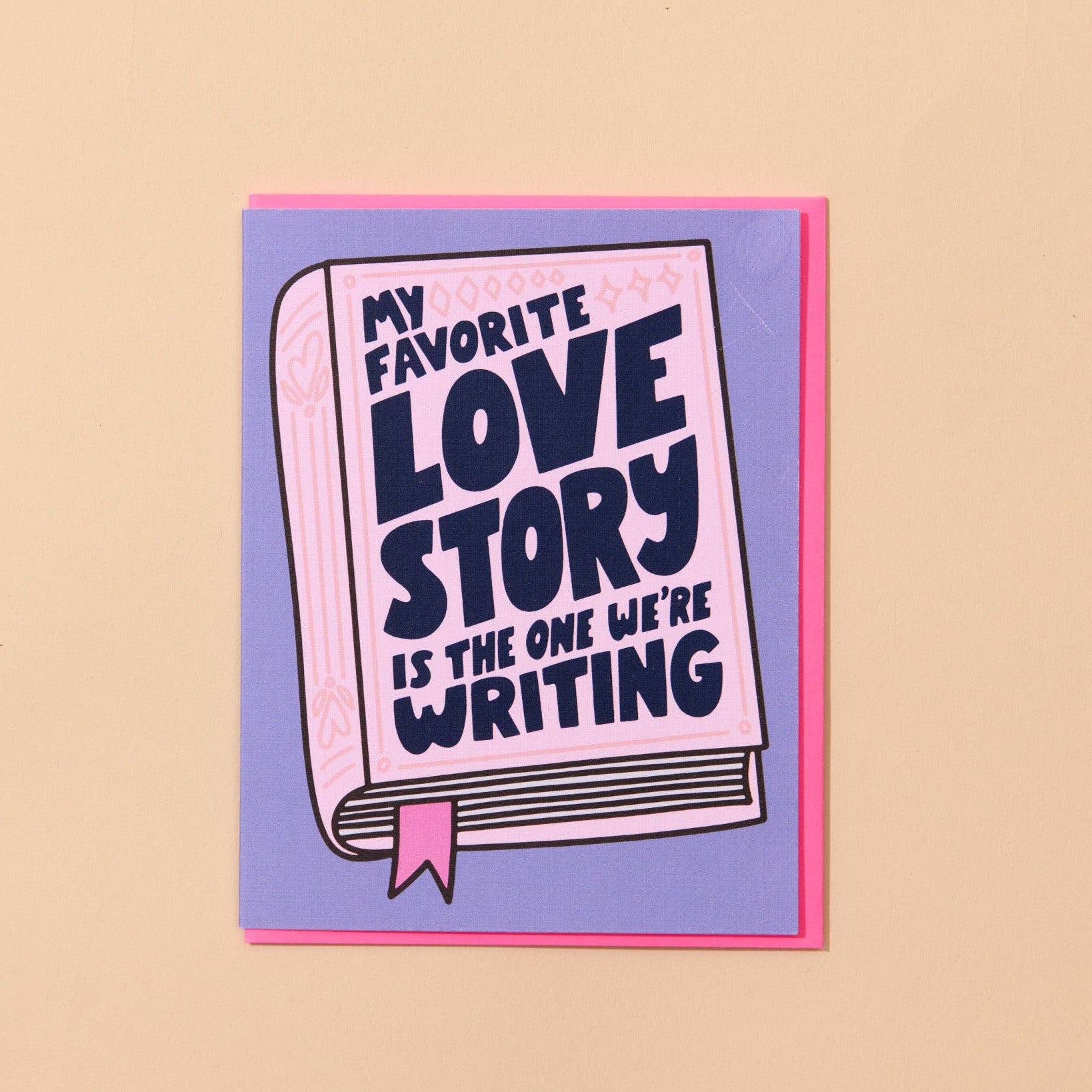 Card with 'My favorite love story is the one we're writing' text on a beige background