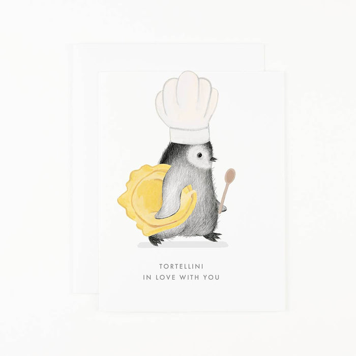 A greeting card featuring a graphite penguin with a chef's hat and a plate of tortellini. The penguin is holding a spoon, and the card has the text 'Tortellini in Love with You'.