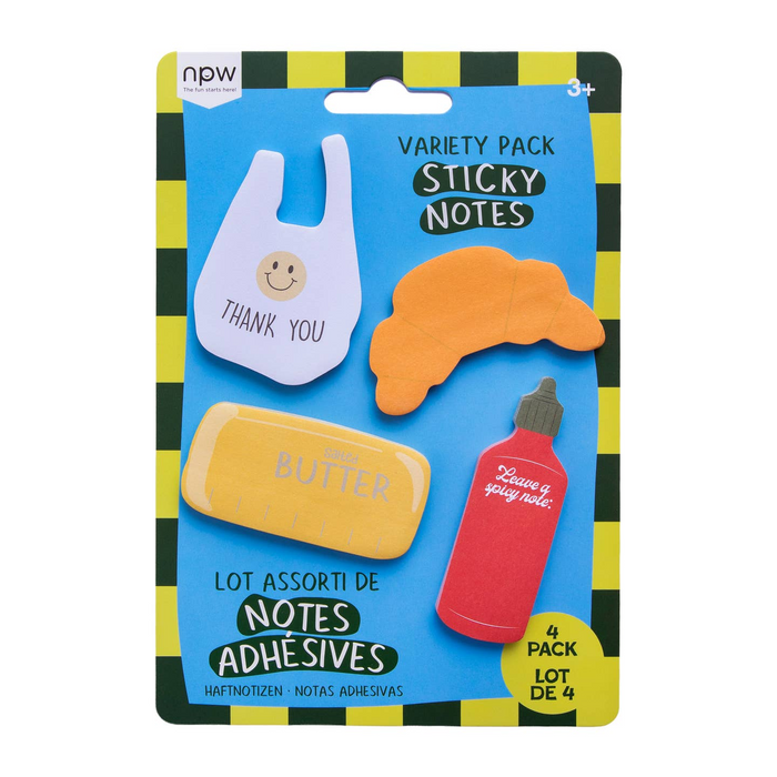 A package of four novelty sticky notes shaped like a bag, a croissant, a stick of butter, and a red bottle, on a blue backing card with a black and yellow striped border.