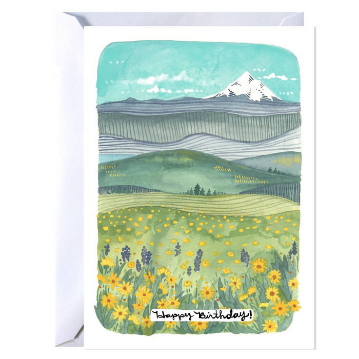 Greeting card with a mountain and field design, featuring 'Happy Birthday!' text.