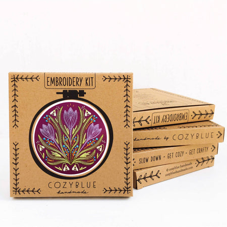 Embroidery kit packaging with floral design and 'CozyBlue' branding on a white background